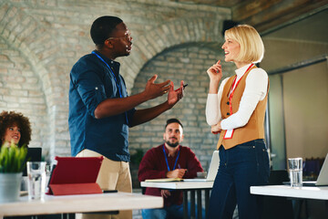 Engaging Office Conversation Between Diverse Colleagues During Team Meeting And Collaboration In Modern Workspace Today
