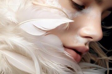 Close up beauty portrait of attractive model with white feathers and creative makeup posing in studio