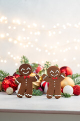 Two gingerbread men are smiling and standing next to each other