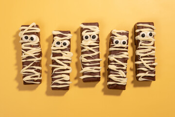 Three chocolate bars with white icing and black eyes