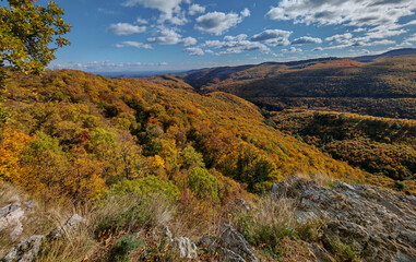 Expansive autumn landscape from Magos-kő in the Bükk Mountains, overlooking the Garadna Valley covered in colorful beech forest.