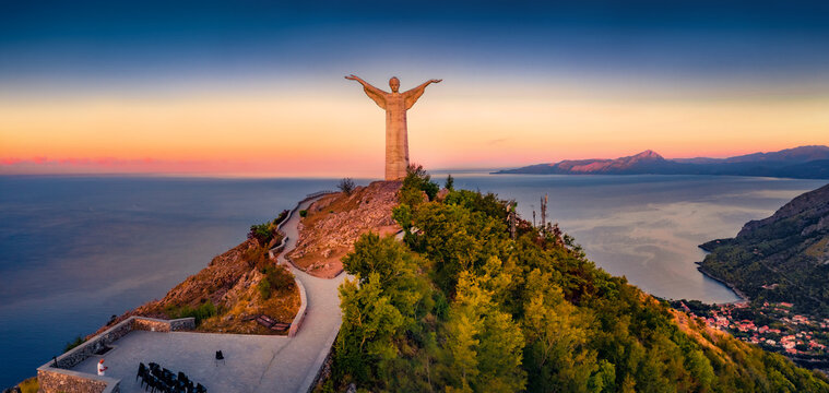 MARATEA, ITALY - AUGUST 31, 2021: Stunning summer sunrise on Statue of Christ the Redeemer. Great morning seascape of Mediterranean seascape. Aerial outdoor scene of Italy, Europe.