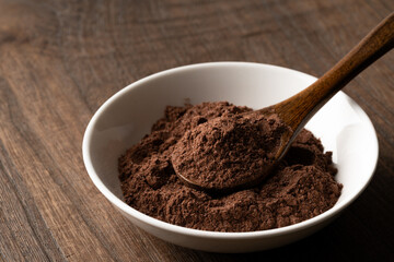 小皿の上のスプーンに載せた砂糖入りのココアの粉のクローズアップ