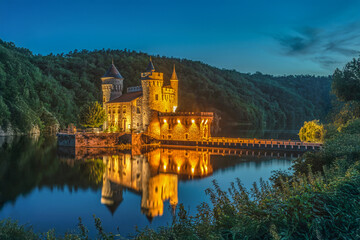 Fototapeta premium Lac de la Roche dans la Loire avec son château illuminé dans la nuit