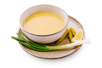 Creamy sauce served with fresh greens and lemon on a clay plate