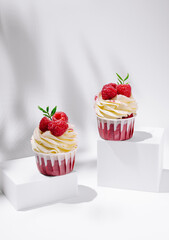 Delicious raspberry cupcakes on white display with elegant frosting