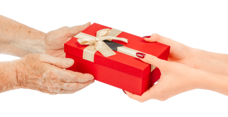 Elderly and young hands exchanging a red gift box with a gold ribbon and bow, isolated on white background. Concept of giving, love, care, generations, family connection, and holiday celebration