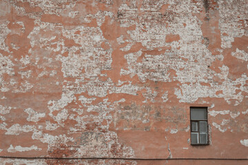 An old firewall in the city center. A wall with a single window.
