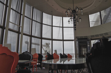 Formal and elegant ocean view a la carte dining room restaurant onboard luxury cruiseship cruise ship liner with set tables in leather and wood Art Deco interior design style ceiling ambient lighting