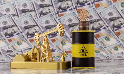 A miniature gold oil pump against a backdrop of $100 bills.