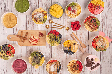 A still life of a healthy bowl filled with chocolate cream, lots of fruits and roses