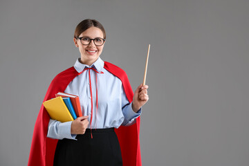 Teacher wearing superhero cape on grey background. Space for text © New Africa