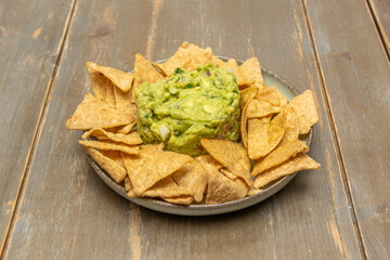 Mixed nachos with layers of different meats, cheeses, and salsas presented on a large platter