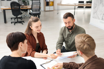 Business process. Colleagues working together at desk in office