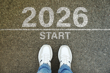 New Year. Man standing in front of line with word Start and numbers 2026 on asphalt, top view