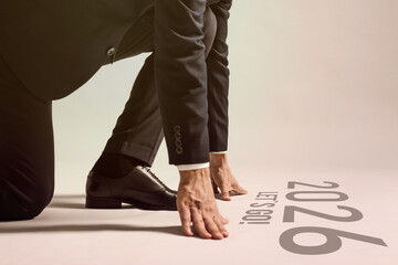 New 2026 Year. Businessman in starting position in front of phrase Let's Go! and numbers on floor,...