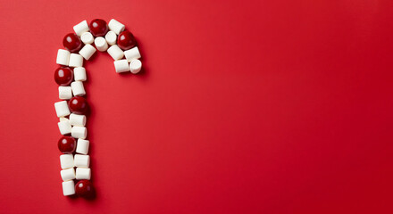 Minimalist candy cane flat lay with copy space on a bright red background