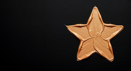 A thick bronze paint smear star on a black background 