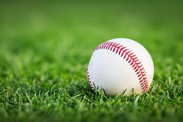 Baseball sitting on a green grass field, symbolizing sport, competition, and outdoor summer activities