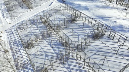 Metal carcass of future pavilion on snowy construction site aerial view. Steel beams frames of building in winter forest. Architecture - Powered by Adobe