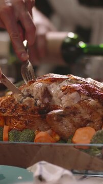 Vertical slow motion video carving roasted turkey on festive table with vegetables soft warm light holiday dinner thanksgiving christmas family celebration gratitude cozy atmosphere