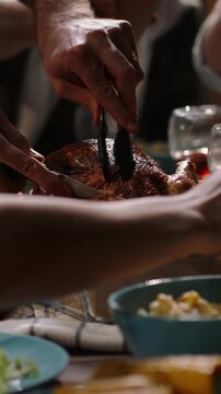 Vertical video camera moving over festive table people serving salad pouring wine carving turkey background cozy light thanksgiving christmas celebration gratitude home warmth