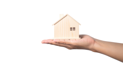 A hand holding a miniature wooden house
