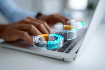 Employee using laptop with 3D holographic pie charts floating