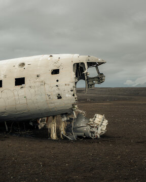 View of the haunting shell of a wrecked DC-3 plane rests on the stark black sands under a heavy sky, a monument to time and isolation, S&oacute;lheimasandur, Myrdalshreppur, Iceland.