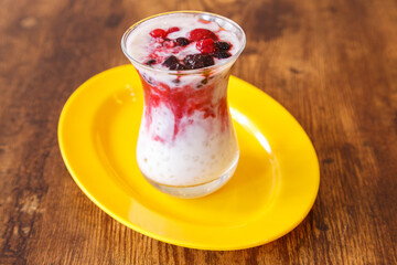 Sago aux fruits rouges – dessert malaisien à base de perles de tapioca, lait de coco et gelée maison, présenté dans une assiette colorée sur table en bois