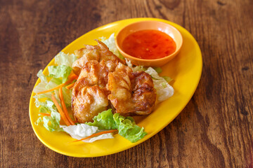 Bread ball - boulettes croustillantes au porc avec sa sauce sweet and chill présentées dans une assiette colorée sur table en bois