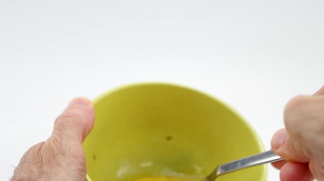 Dettaglio mani che sbattono con una forchetta tuorlo e albume di uova per una frittata, sfondo bianco