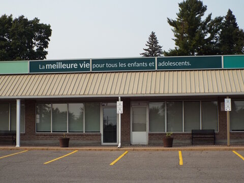 Vanier, ON, Canada-May 23,2025: An office storefront with a sign in French stating the mission: "La meilleure vie pour tous les enfants et adolescents" at 310 Olmstead .