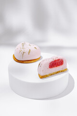 Delicious dessert display featuring pink mousse treats on a white pedestal