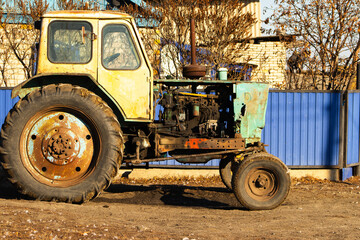 Weathered Vintage Farm Tractor in Sunlight by a Rustic Fence