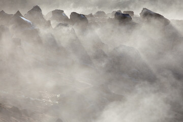 View of jagged, dark rocks piercing through swirling, ethereal mist, creating a dramatic, otherworldly landscape, Iceland, Iceland.