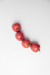 Flat lay of ripe red tomatoes on a white background