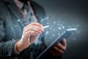 Modern technology and business concept. Man using digital pen on tablet with glowing data network connections. Symbol of innovation, creativity, and digital transformation.