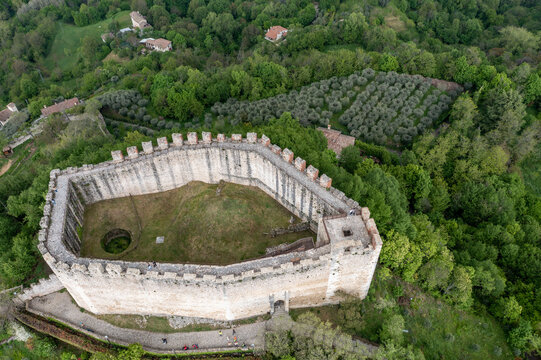 Aerial view of the Rocca d'Asolo, its ancient stone walls standing proud amidst a sea of verdant trees, a testament to history and resilience, Asolo, Veneto, Italy.