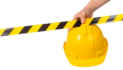 A hand holds black and yellow caution tape horizontally, partially obscuring a yellow safety helmet behind it, against a light gray background.