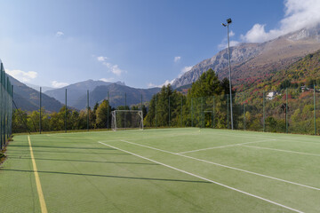 Football field with forest and mountain in back, Alps, Italy