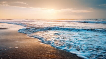 Warm sunset light illuminates foamy blue ocean waves rolling onto dark sandy beach