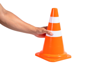 A hand holds a bright orange plastic traffic cone with white reflective stripes, isolated on a light gray background, symbolizing construction or caution.