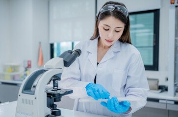 Scientist conducts lab research using a microscope and preparing samples in a modern laboratory setting
