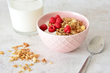 Healthy Breakfast Bowl with Yogurt, muesli and Raspberries and a glass of milk