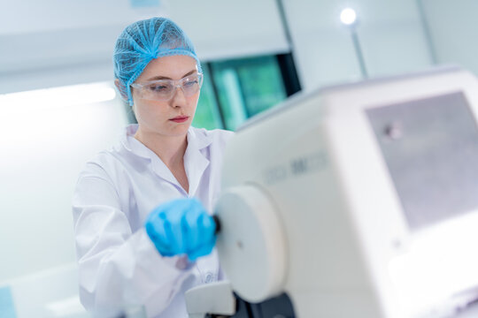Laboratory technician performing equipment calibration in a modern lab setting during daytime