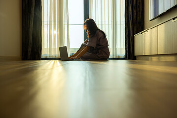 Moving, relocation and New home concept - Happy young woman sitting with laptop on floor at new apartment, imagining interior design, planning flat decoration after moving to own apartment. Copy space