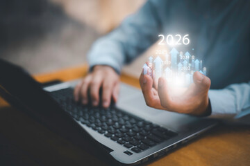 Businessman drawing digital growth arrows and bar graph with 2026 target. Futuristic concept for business goals, technology strategy, data-driven planning, success and innovation.