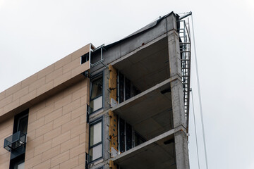 A fragment of a modern multi-story building under construction or reconstruction. The architectural structure and stages of creation of a residential or office complex.