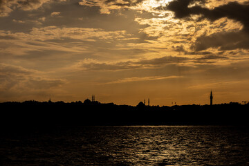 Fototapeta premium Dramatic Istanbul skyline silhouette with mosque minarets and domes at golden sunset